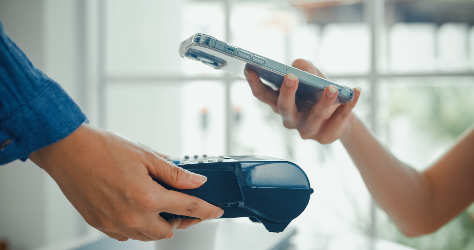 Close-up of a customer using a smartphone to make a contactless payment at a cafe, highlighting the convenience of mobile payment technology. Cafe lifestyle.
